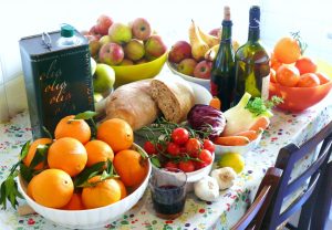 Una tavola  con prodotti tipici della dieta mediterranea italiana: olio d'oliva, pane, agrumi, pomodori, finocchi e carote
