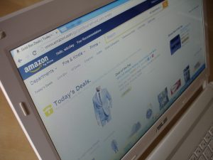 Schermo di un notebook che mostra il sito Amazon con offerte e promozioni, simbolo degli acquisti online