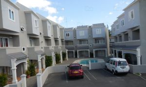 Complesso residenziale moderno con appartamenti in affitto, piscina e parcheggio, ideale per vacanze