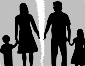 Silhouette di una famiglia divisa da una lacerazione, con genitori e figli separati, simboleggiando il diritto di famiglia e le consulenze legali per divorzi