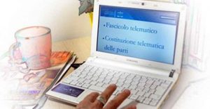 Una persona digita su un laptop Samsung bianco, con lo schermo che mostra Fascicolo telematico e Costituzione telematica delle parti, evidenziando l'innovazione digitale nel diritto