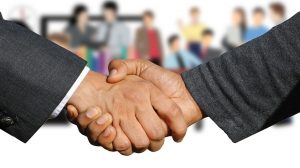 Due persone in abiti formali si stringono la mano, simbolo di accordo e consulenza legale per la pace fiscale