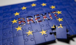 Un puzzle con la bandiera dell'UE e la parola BREXIT ritagliata, con un pezzo mancante. Simboleggia le implicazioni legali ed economiche della Brexit