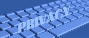 La parola PRIVACY in maiuscolo su una tastiera blu, simboleggia la tutela dei dati personali e la transizione digitale