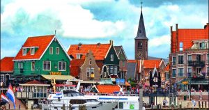 Case tradizionali colorate e un campanile in un pittoresco villaggio olandese, simbolo di opportunità legali