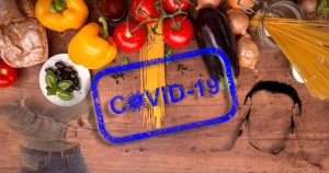 Una persona stressata dal coronavirus tra cibo e pasta, simbolo dei cambiamenti nelle abitudini alimentari durante l'isolamento