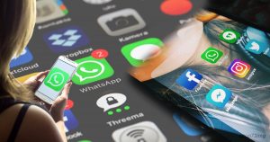 Una persona usa uno smartphone con l'app WhatsApp, sullo sfondo sono visibili app di social media come Facebook, Instagram e Twitter, evidenziando il tema virtuale