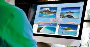 Una persona guarda uno schermo che mostra immagini di spiagge tropicali e resort, simboleggiando le ferie